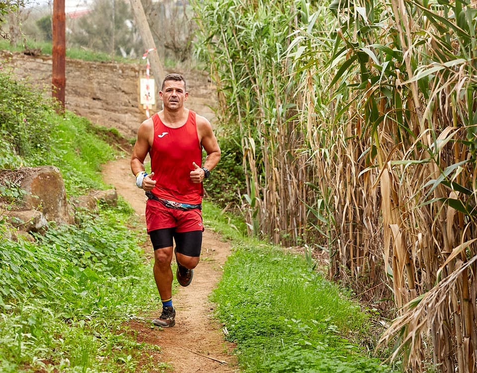 Chico corriendo por la vegetación a través de caminos