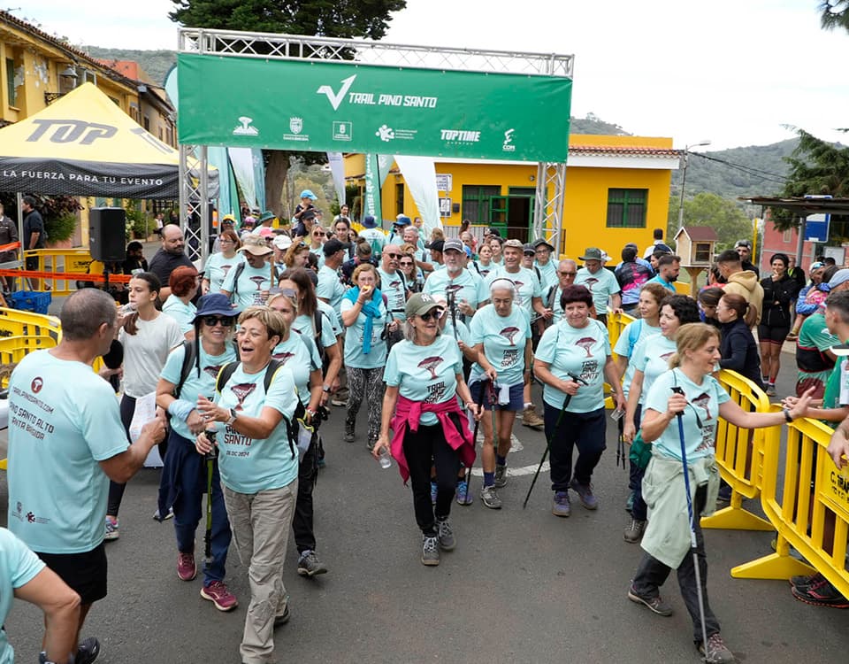 Grupo de senderistas con la camiseta del Trail Pino Santo cruzando el arco de meta en Pino Santo Alto