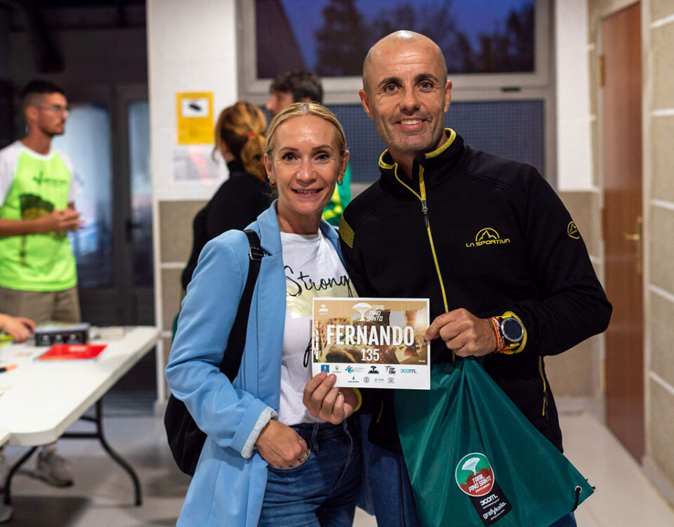 Dos personas sujetando su dorsal de la carrera Trail Pino Santo 2025