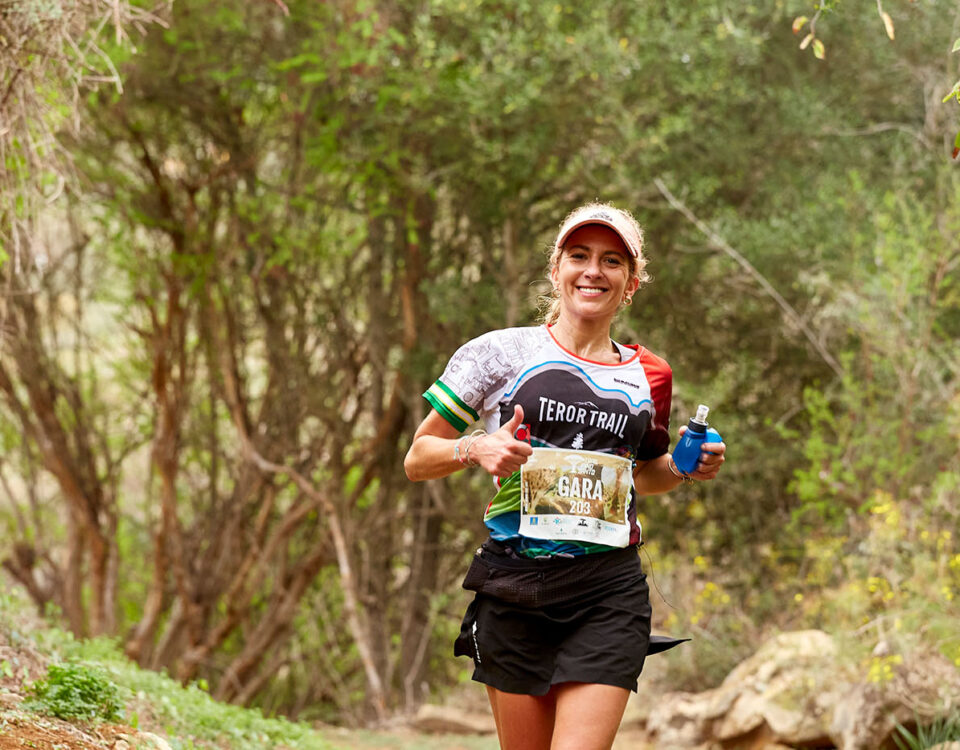 Chica sonriendo corriendo la carrera de la Trail Pino Santo